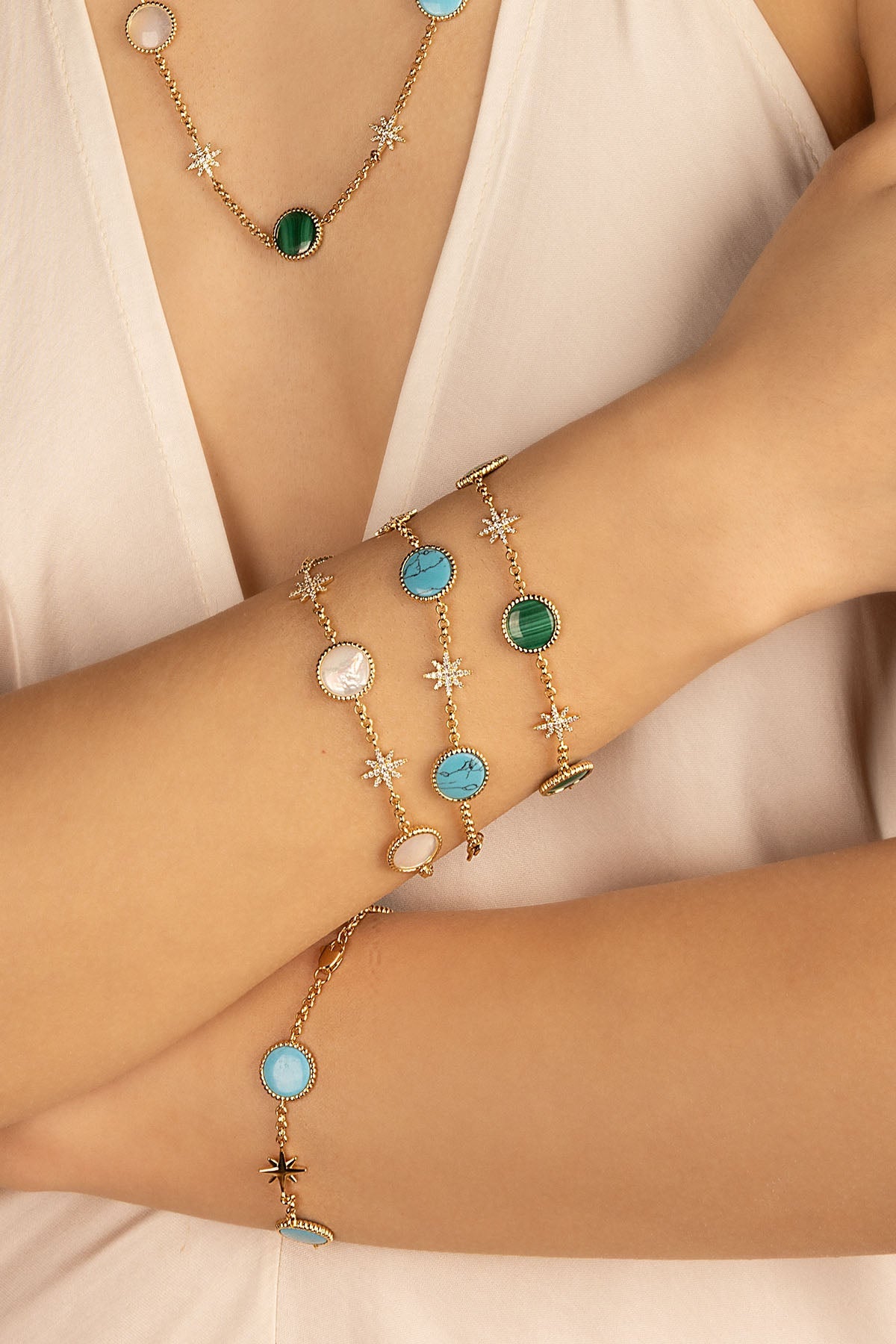 Bracelets APM Monaco. Yellow gold-tone bracelets with lagoon-colored stone accents and multicolor stones in a delicate chain design.