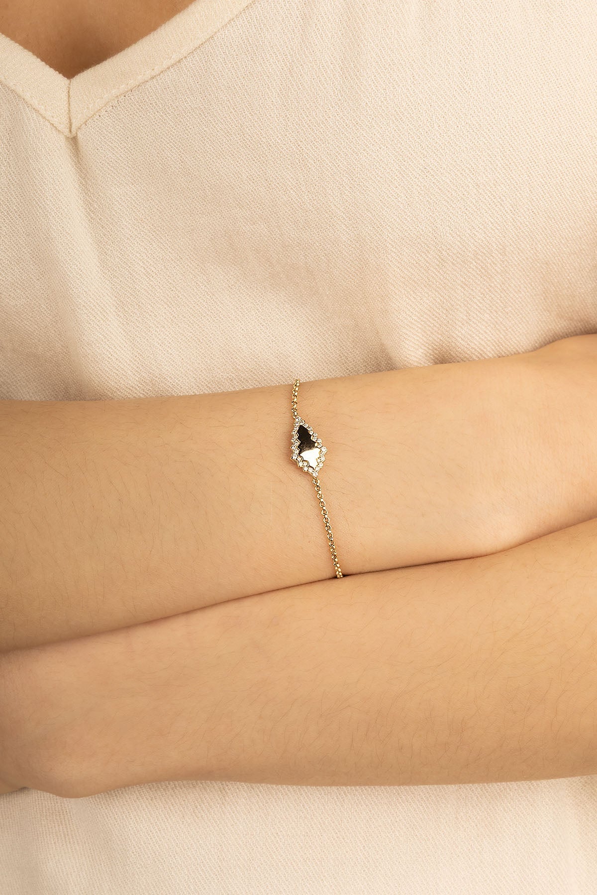 Bracelets APM Monaco, yellow gold-tone adjustable chain bracelet with a black rhombus centerpiece framed by white pavé stones.