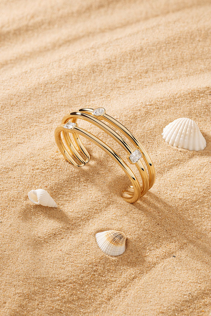 Bracelets APM Monaco yellow gold triple-cuff bracelet with pavé rhinestones.