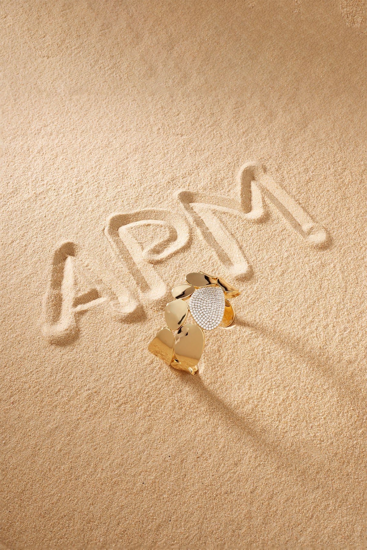 Bracelet APM Monaco, yellow gold with pavé diamonds at the center, statement galet bangle.