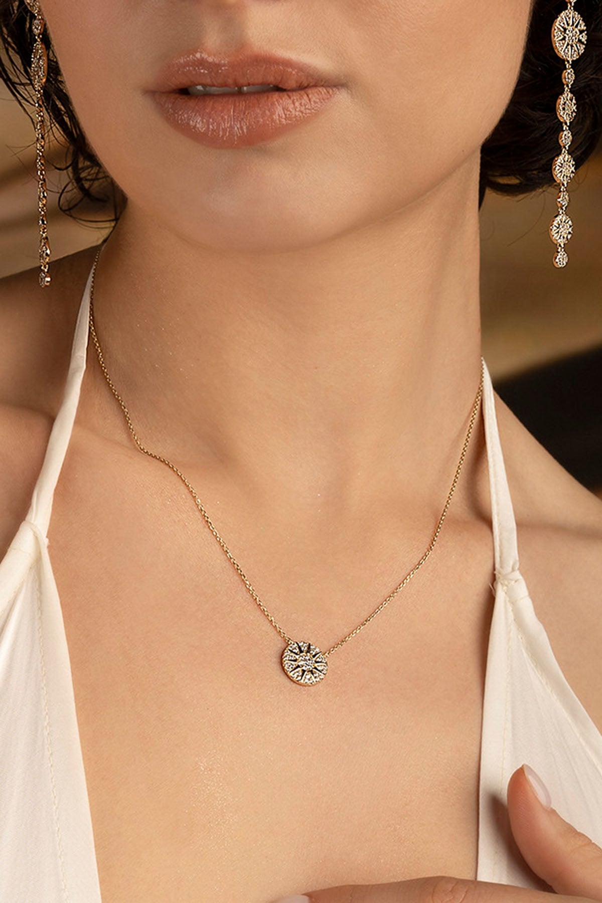 Necklaces APM Monaco: yellow gold chain with a circular sun pendant, paired with matching earrings.