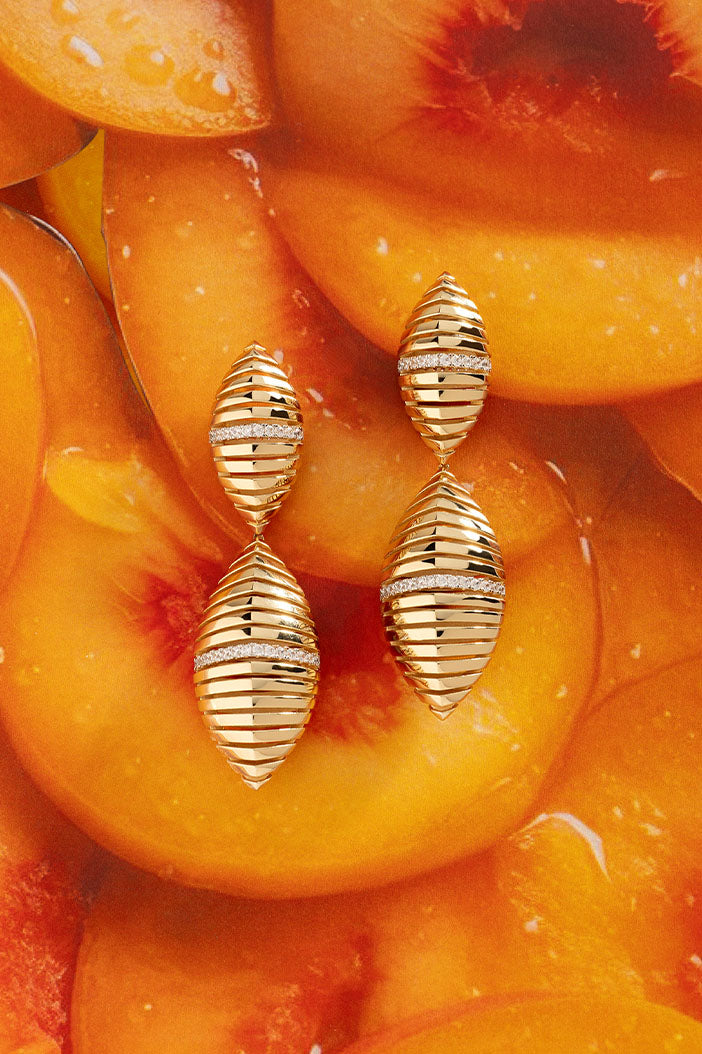 Earrings APM Monaco: yellow gold pieces with a horizontal stripe design and a central pavé diamond row.