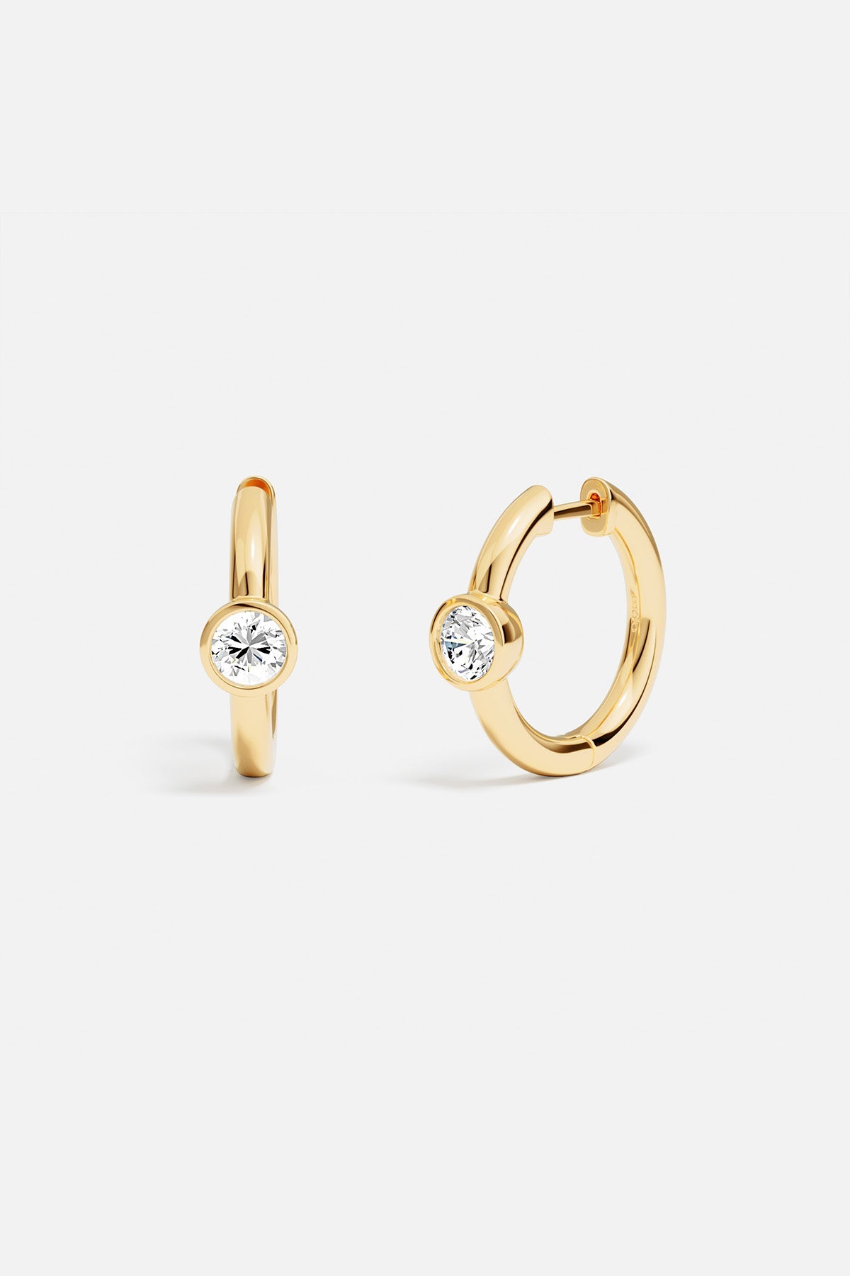 Earrings, APM Monaco: yellow gold hoop earrings with white gemstone accents.
