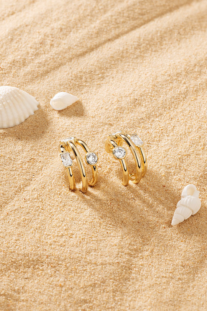 Earrings APM Monaco – yellow gold-tone hoop earrings with crystal pavé accents in a triple-crystal cluster style.