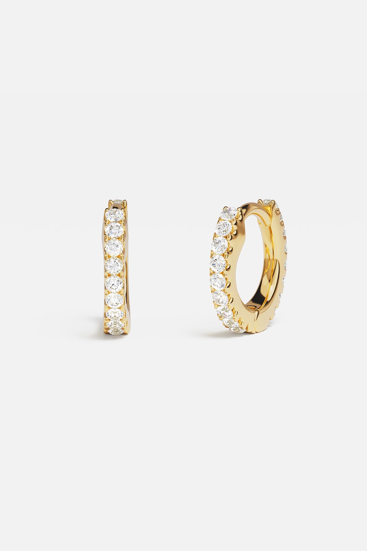 Earrings APM Monaco: yellow gold huggie hoops with white diamonds.