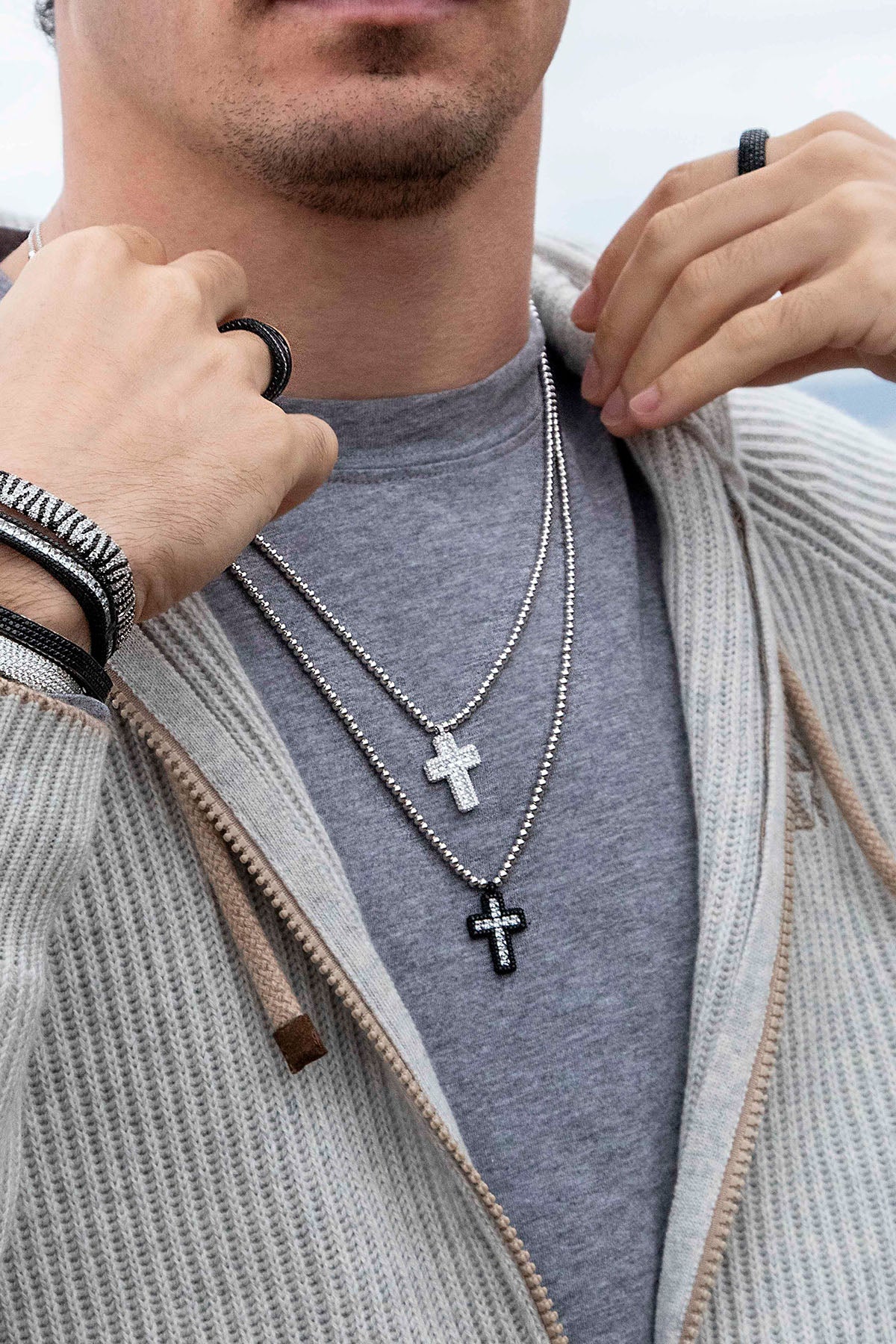Necklaces APM Monaco; silver-tone chain with two cross pendants—one white cross and one black cross adorned with white stones.