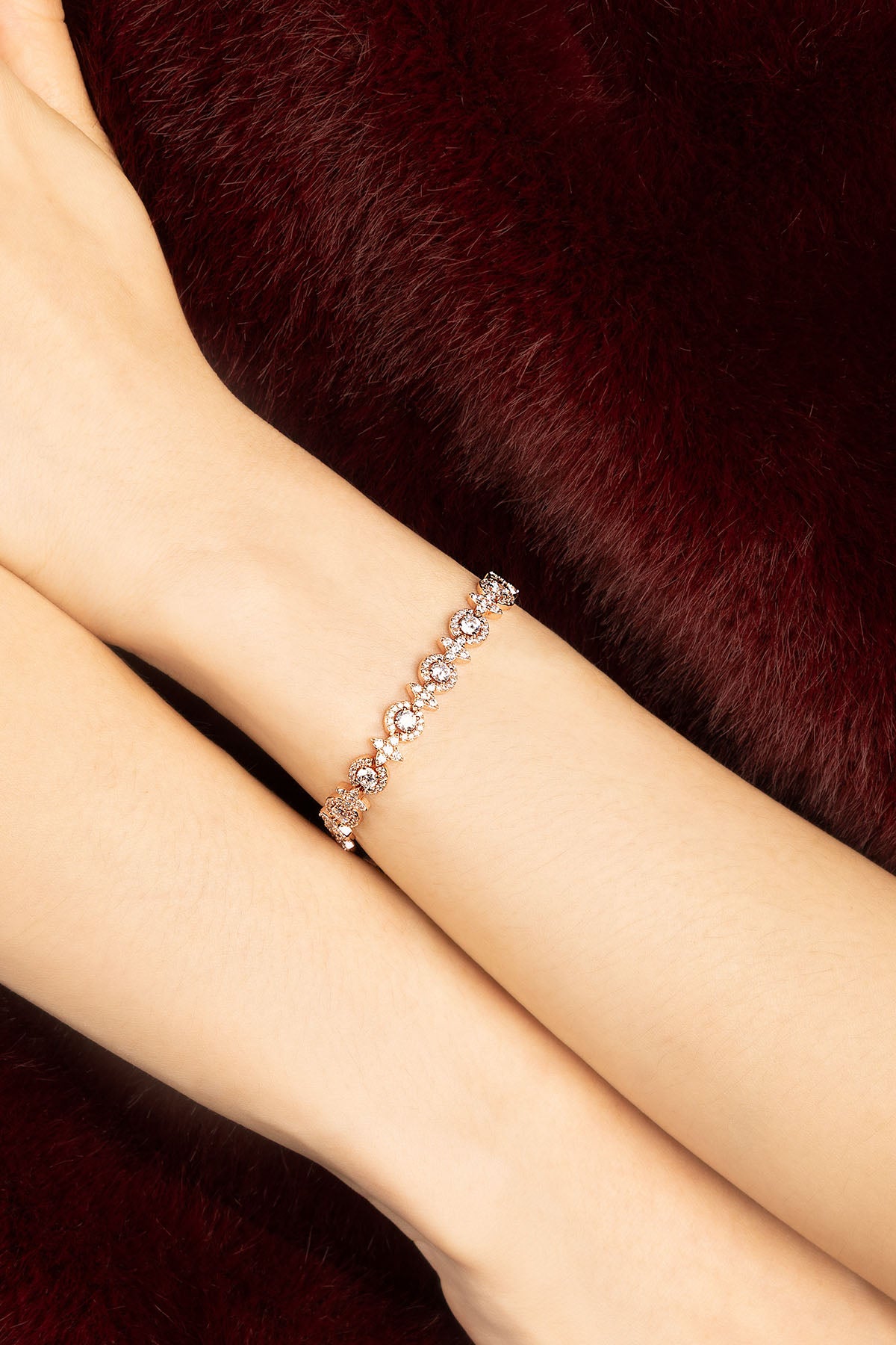 Woman wearing APM bracelet, a delicate sparkle against velvet warmth.