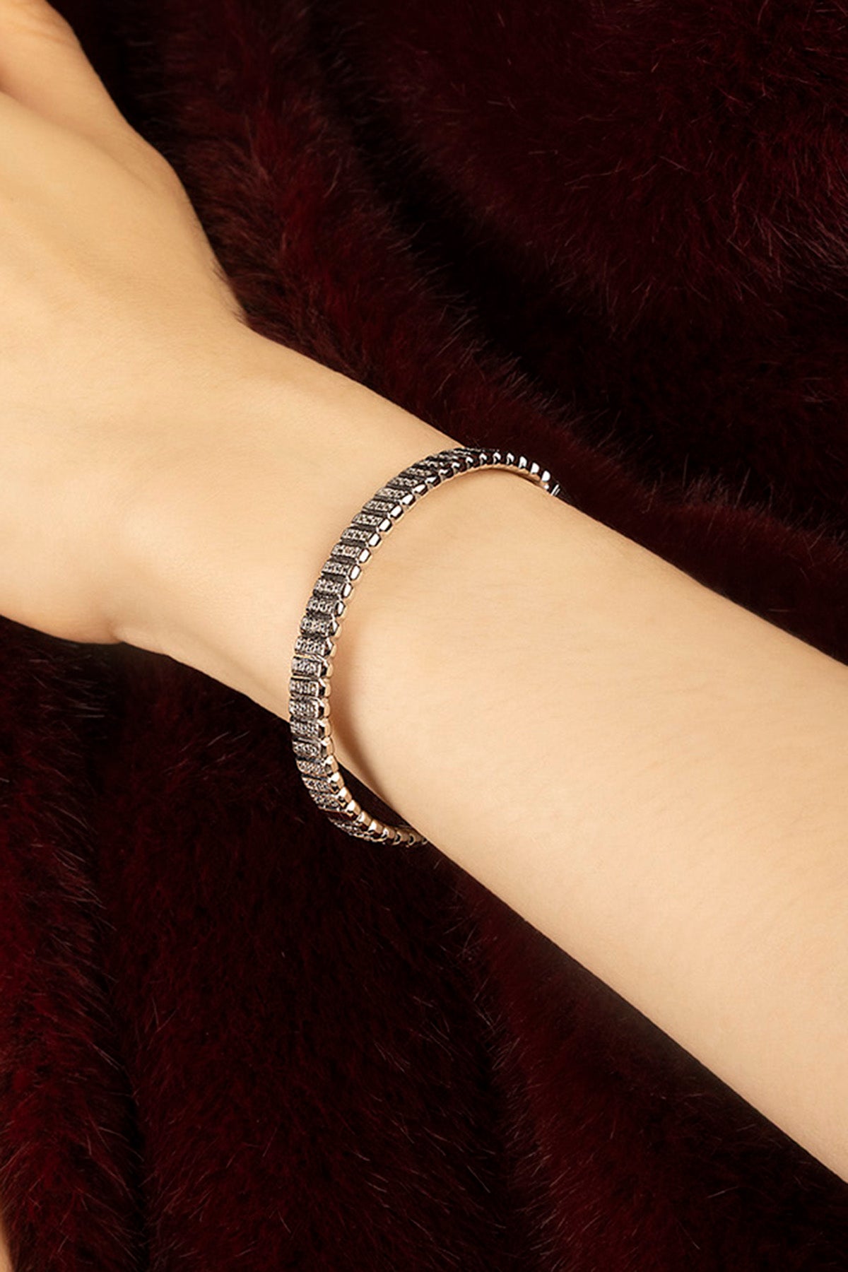 Woman wearing APM Monaco bracelet in rhodium finish, a whisper of quiet glamour.