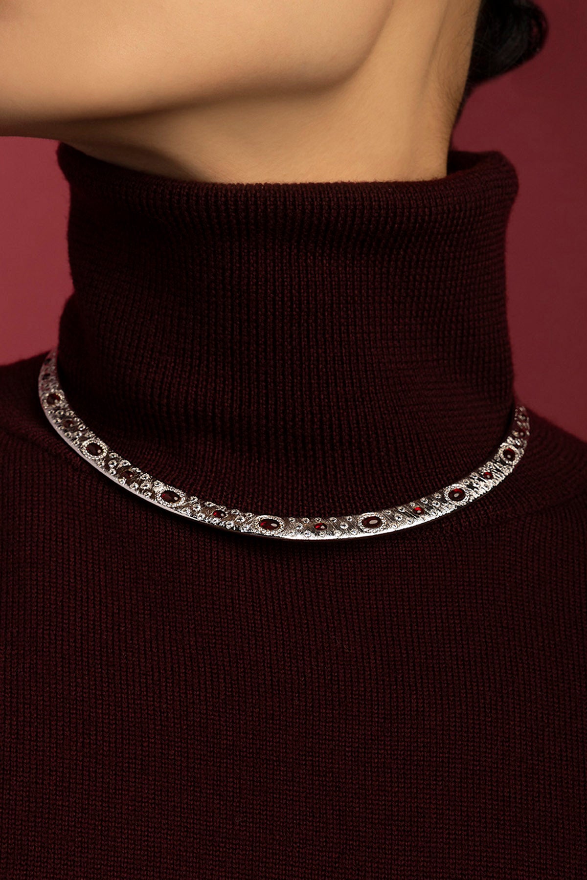 Woman wearing APM Monaco necklace, rhodium finish glowing with crimson allure.
