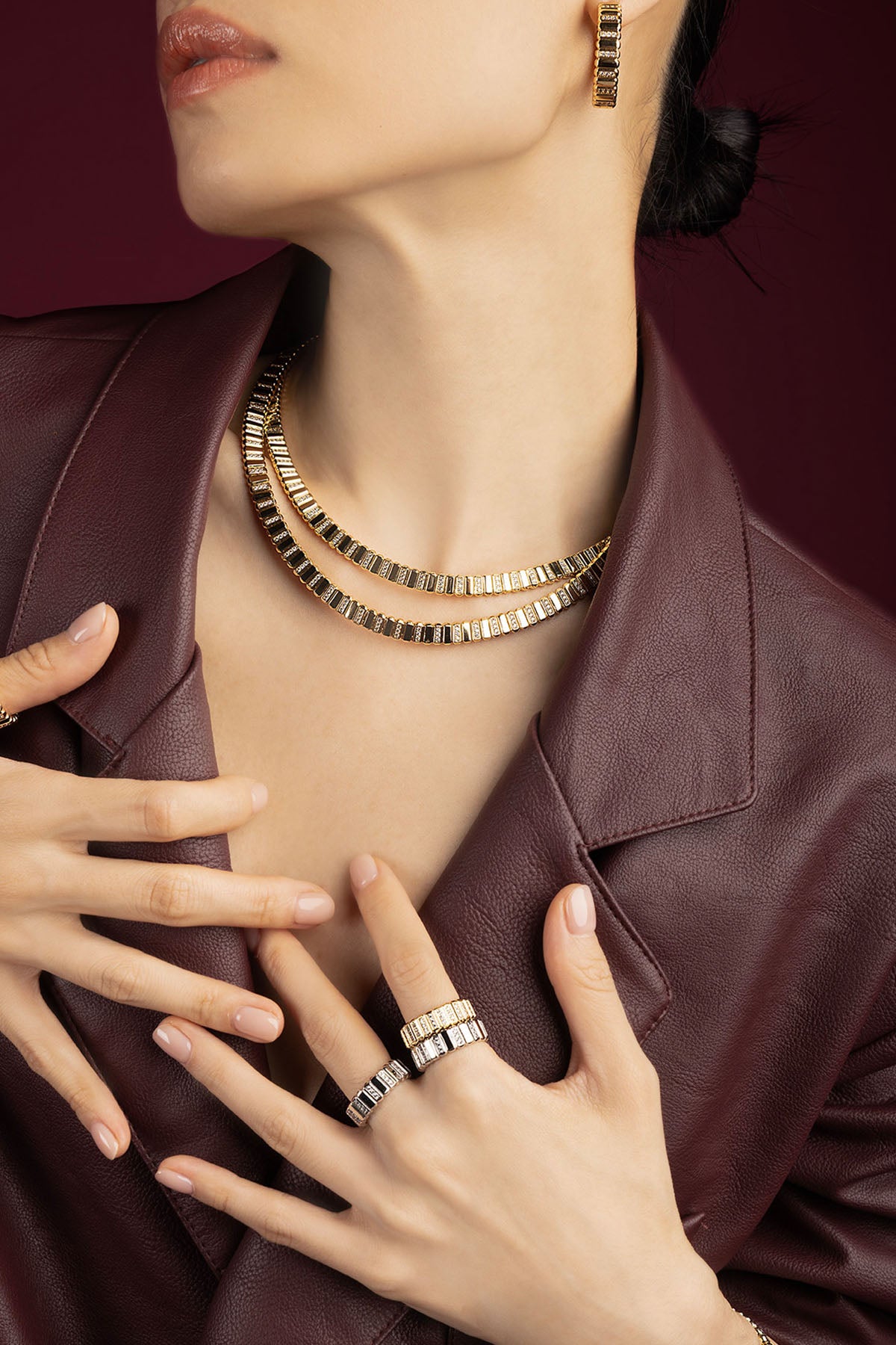 Woman wearing APM Monaco jewelry set, golden allure meets modern sophistication.