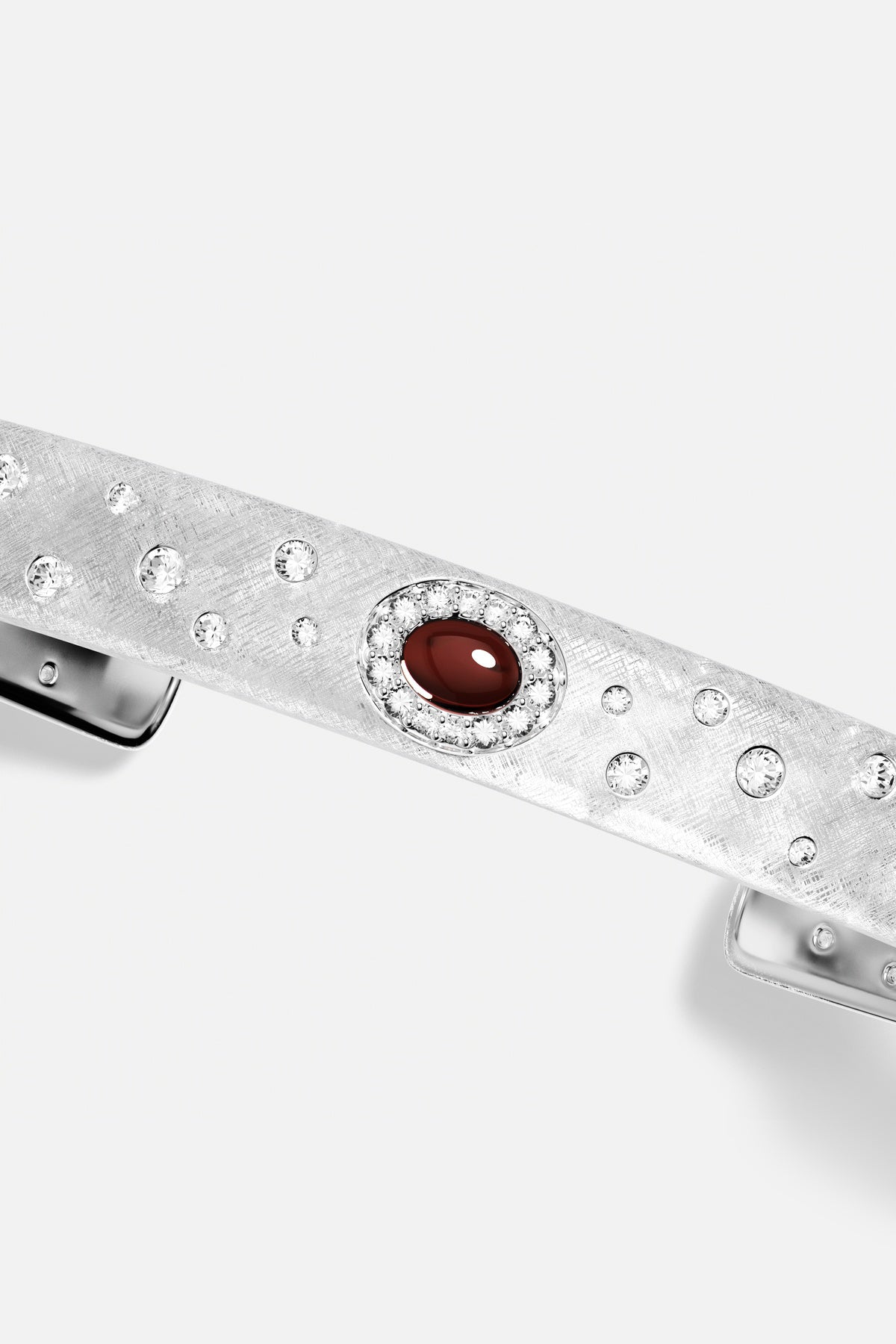 APM hair clip in rhodium finish, a deep red glow amid scattered sparkle.