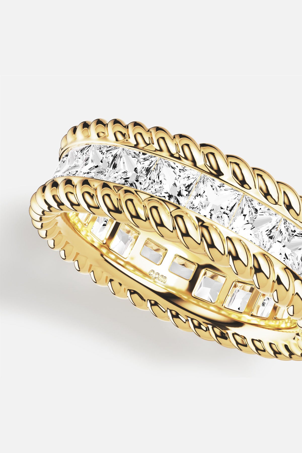 APM Ring in gold color, twisted braids framing brilliant stones, quiet radiance.