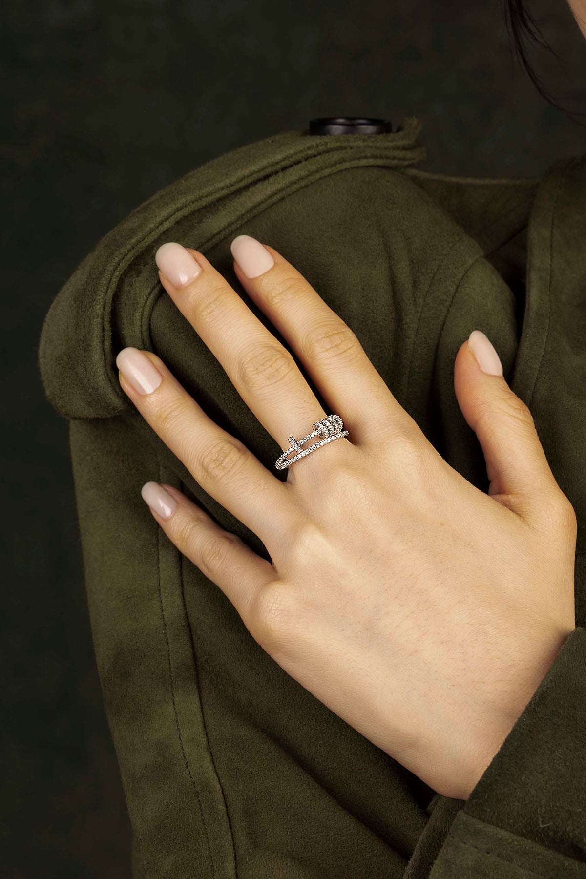 Hand wearing a silver ring on a dark background