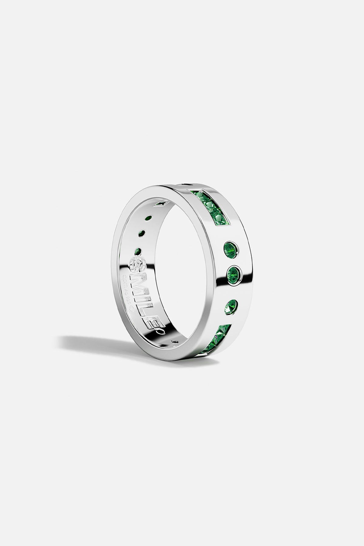 Silver ring with green stones on a white background
