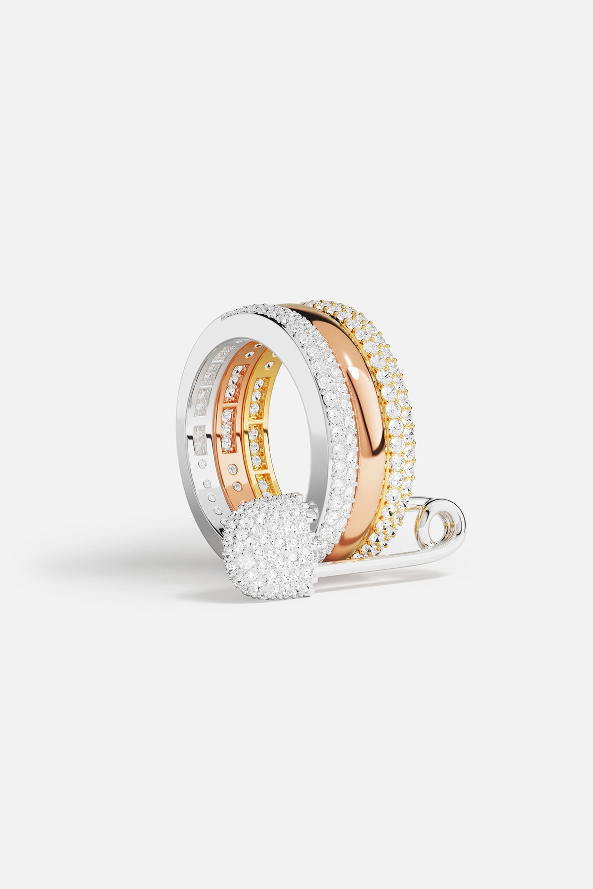 Rings APM Monaco fashion jewelry: a white, triple-hoop safety-pin ring with pavé cubic zirconia, paired with two additional cubic zirconia rings.