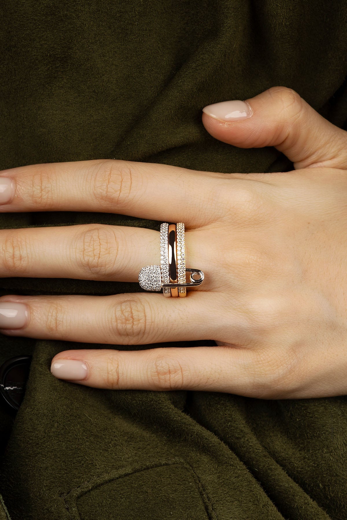 Hand wearing multiple rings on a dark background