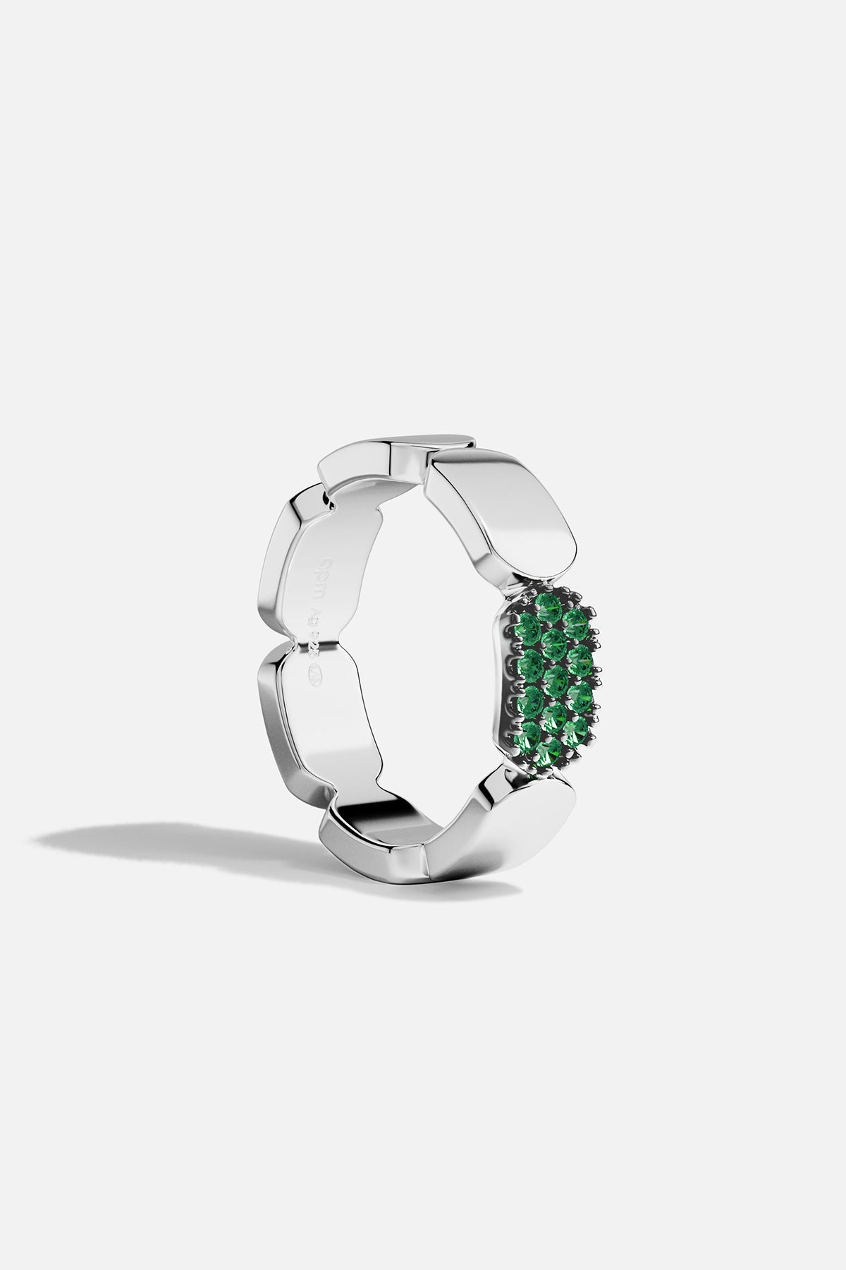 Silver ring with green stones on a white background
