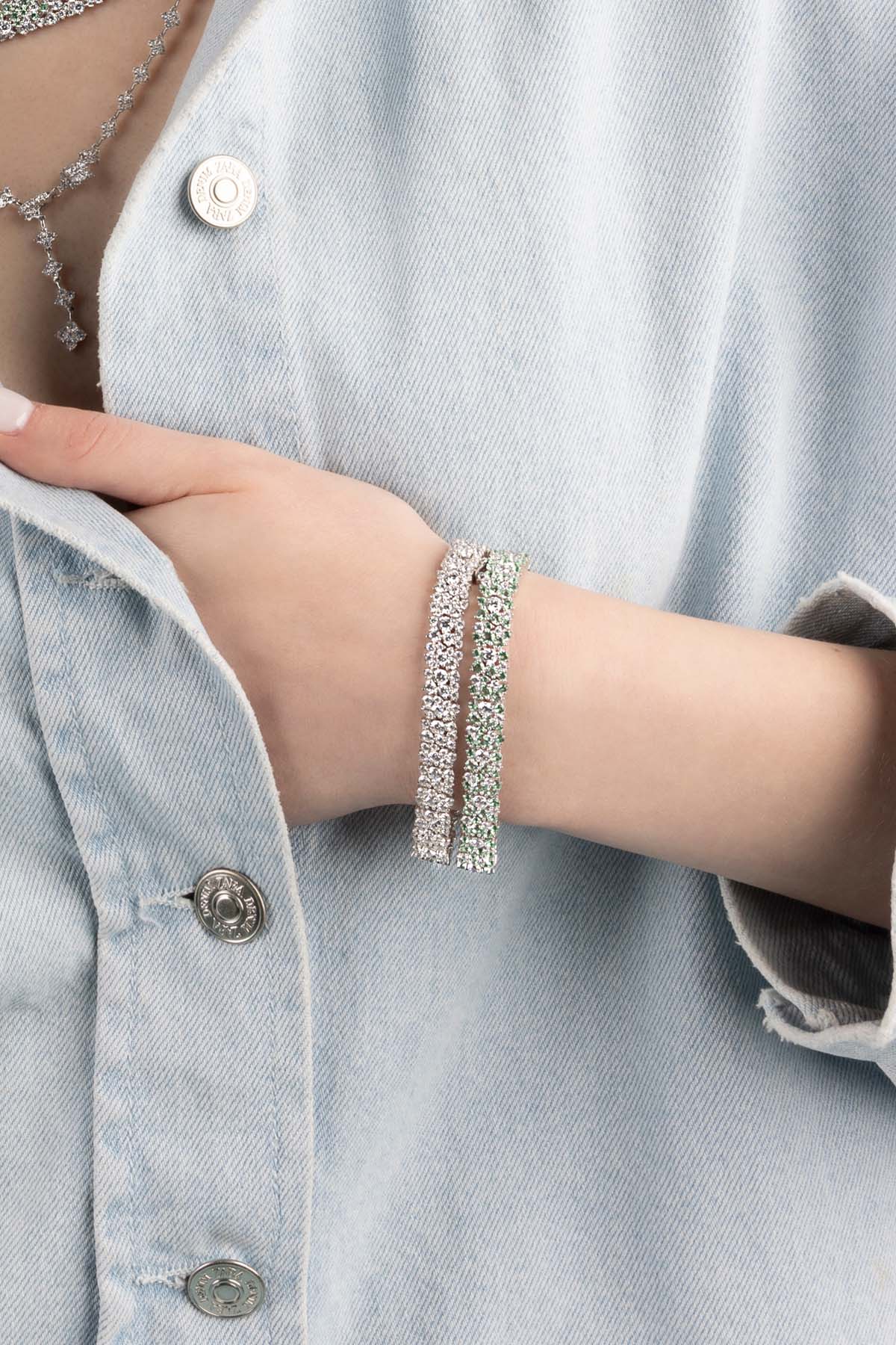 Bracelets APM Monaco, drop style with gemstone beads, two pieces worn on a pale hand.