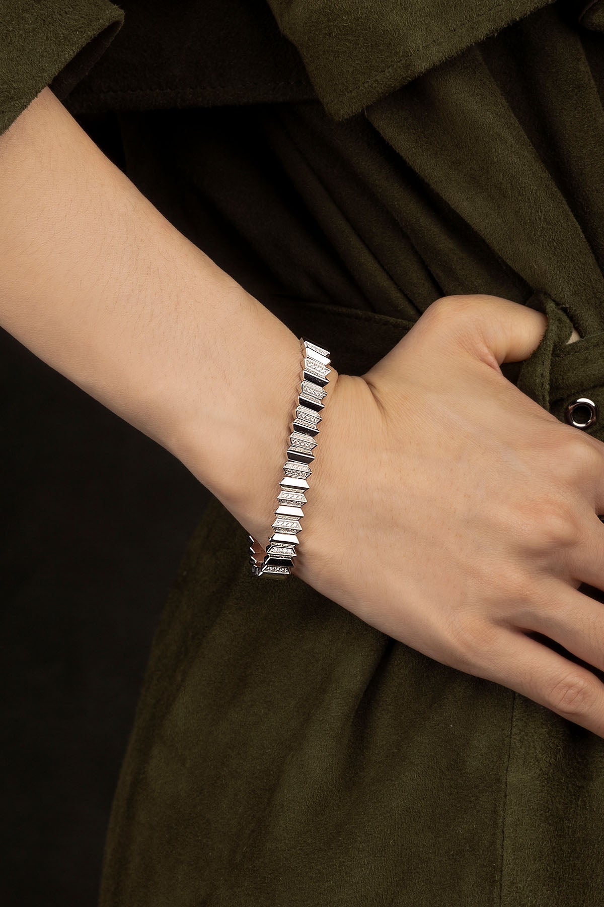 Silver bracelet on a wrist with a dark background