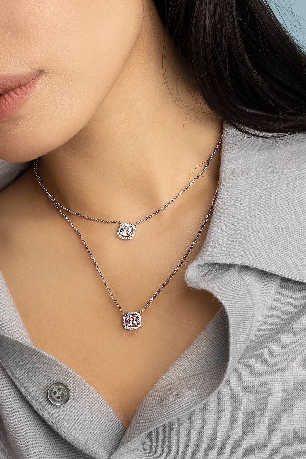 Necklaces APM Monaco. Two delicate pendant necklaces on fine chains, featuring a pink jewel and a clear jewel; silver-tone metal.
