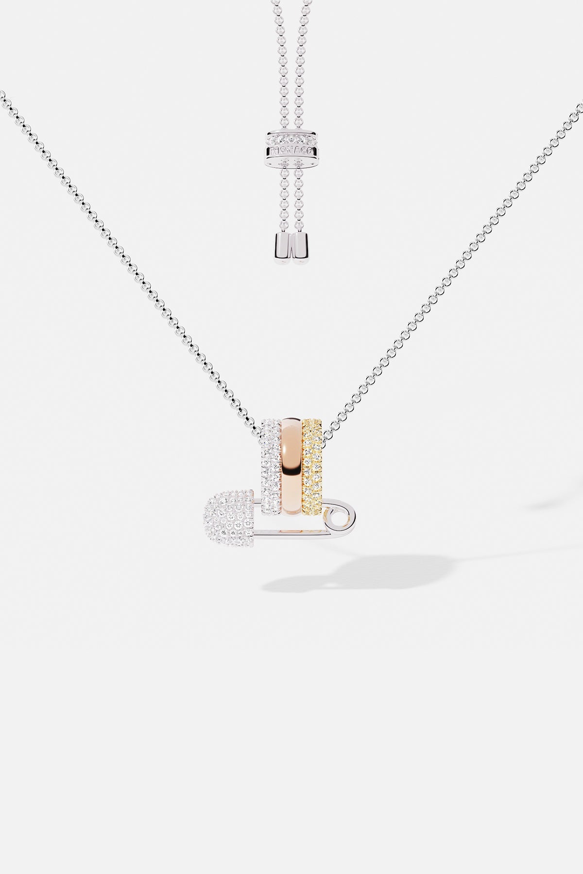 Necklaces APM Monaco multicolor diamond safety-pin pendant on an adjustable white-gold chain with stacked rings.