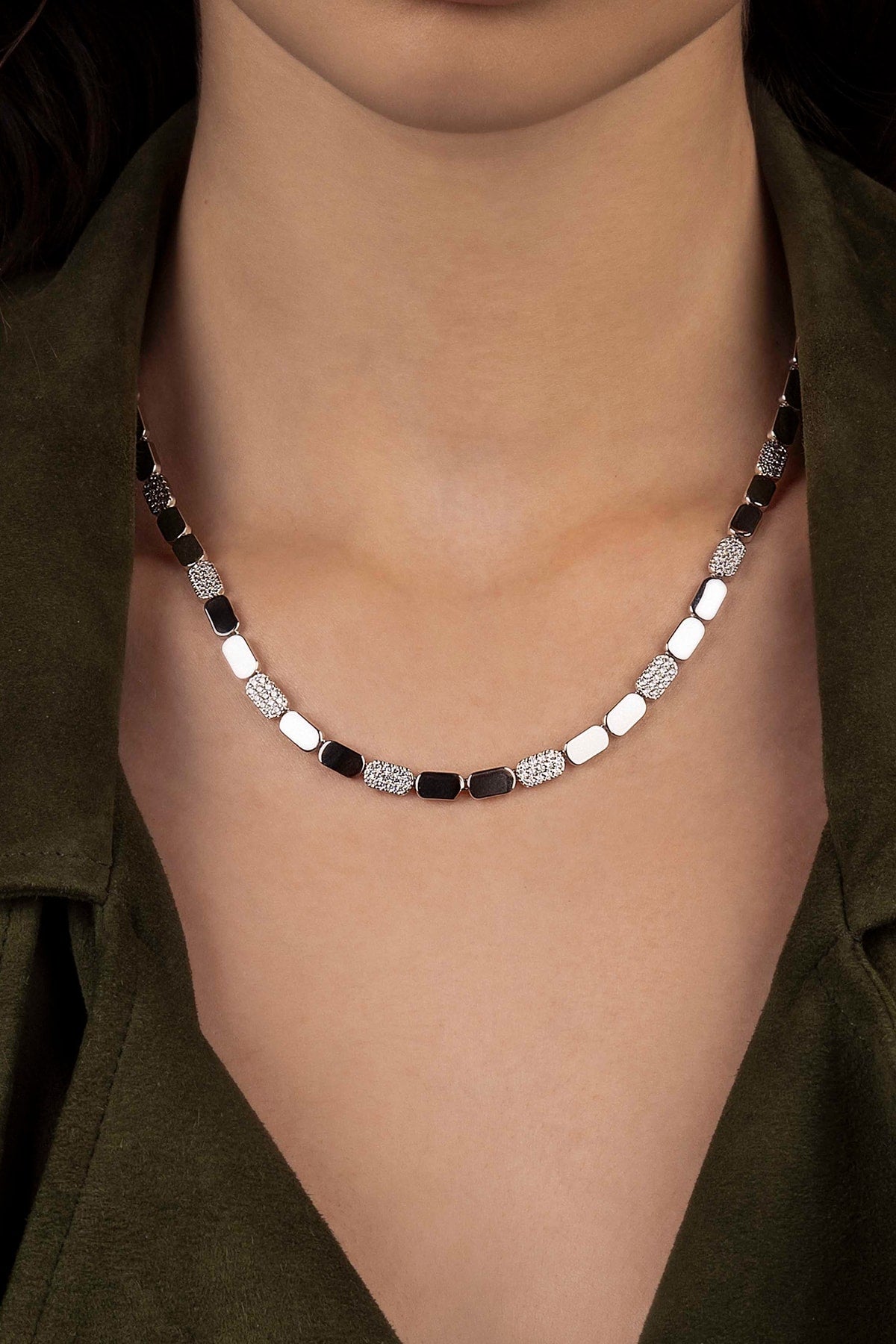 Necklace worn by a model against a dark background