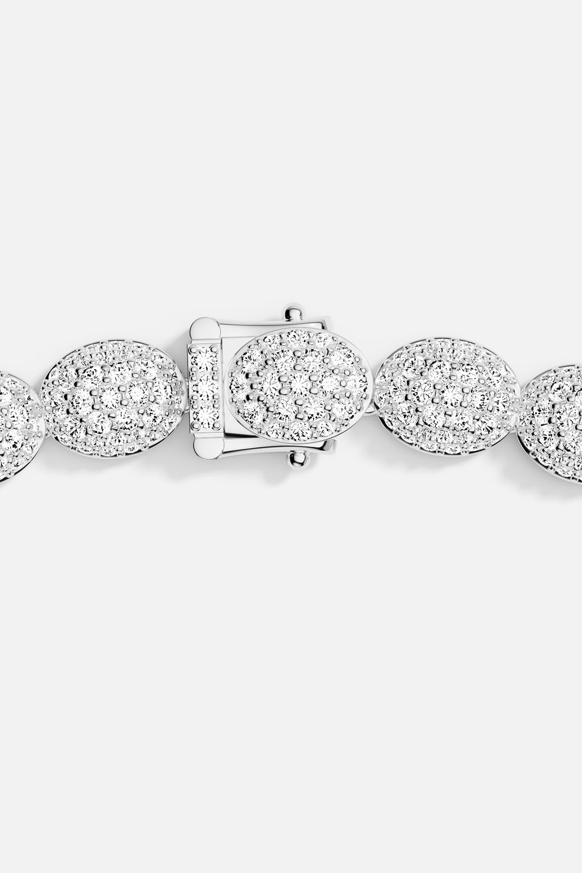 Zoom in of a silver bracelet closing on a grey background