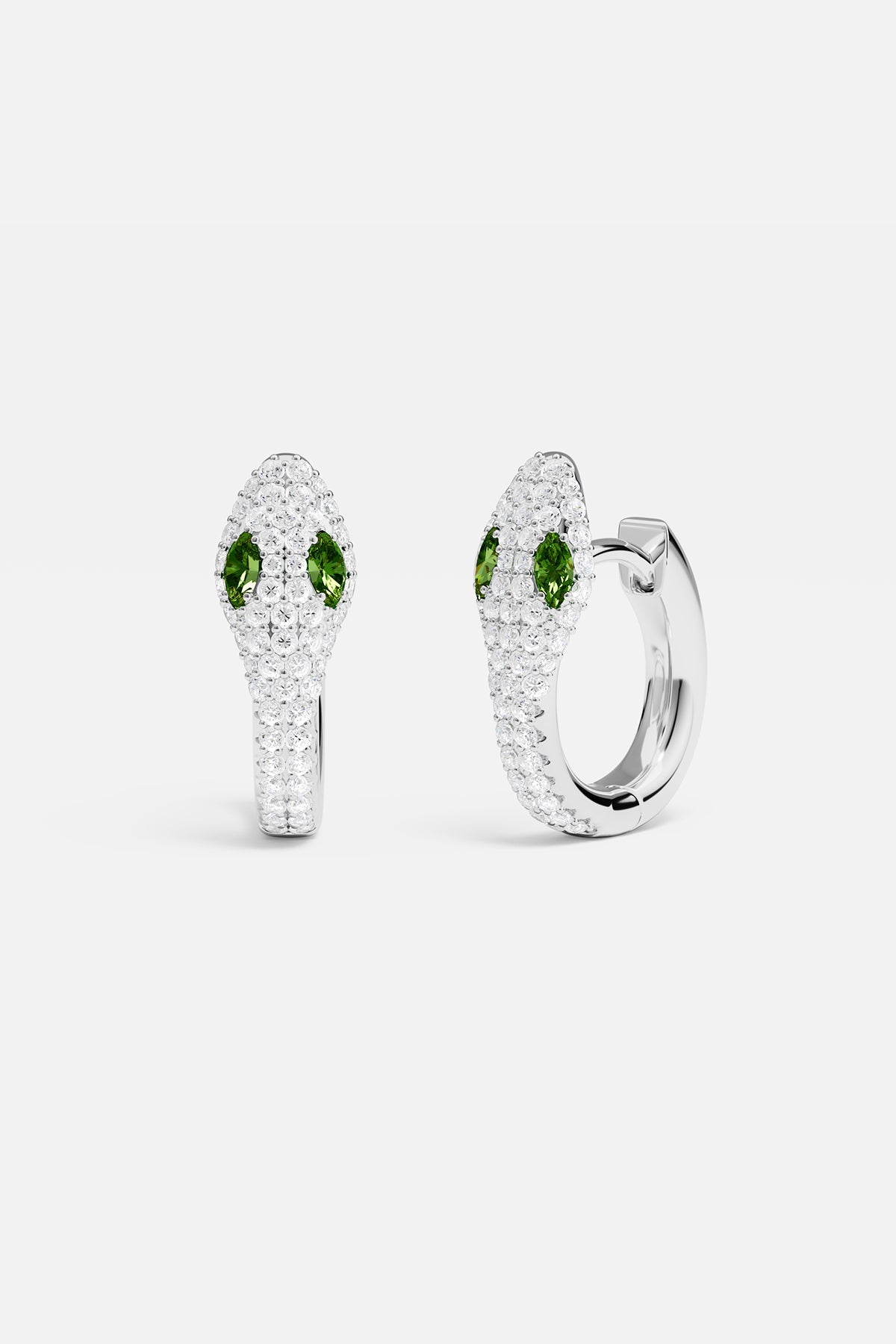 Earrings APM Monaco: white gold serpentine hoop earrings encrusted with white pavé gems and green gemstone eyes.