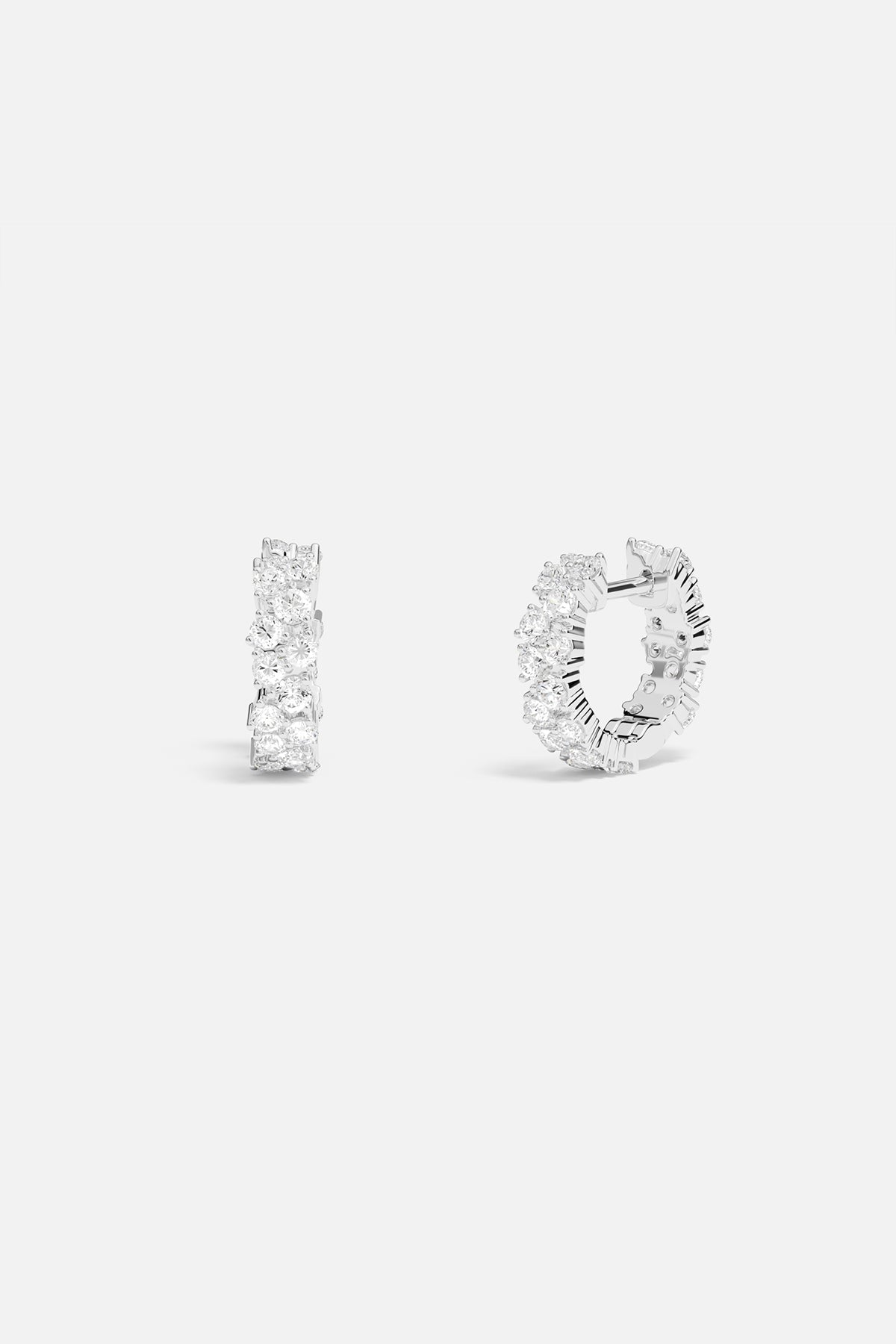 Earrings APM Monaco white pavé huggie hoops with diamond accents.