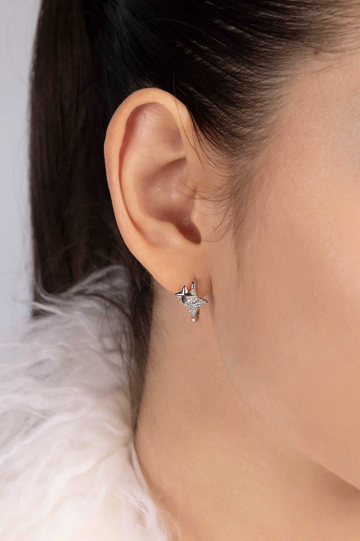 Close-up of an ear wearing a star-shaped earring 