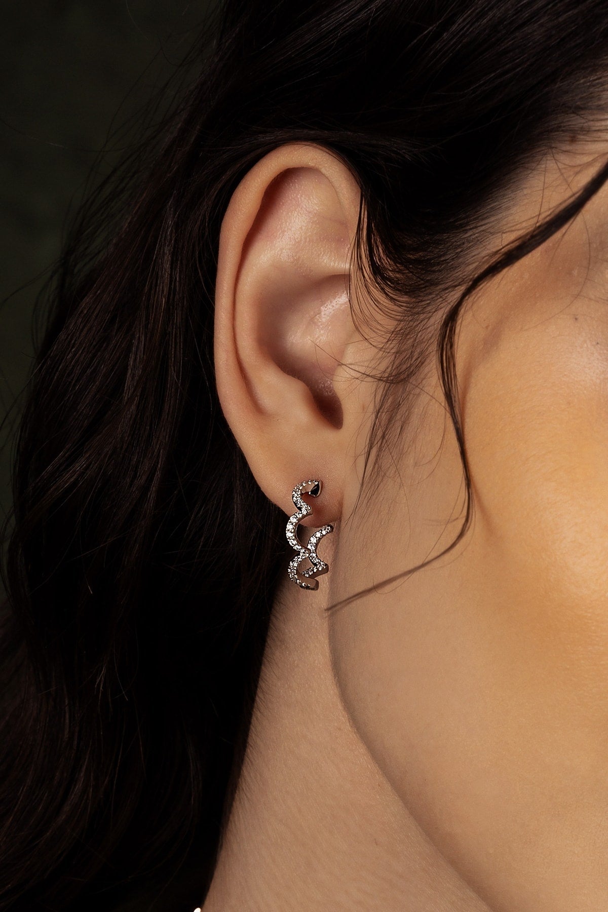 Close-up of an ear wearing a silver earring