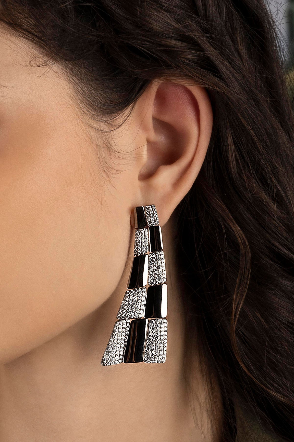 Close-up of a model wearing a silver earring.