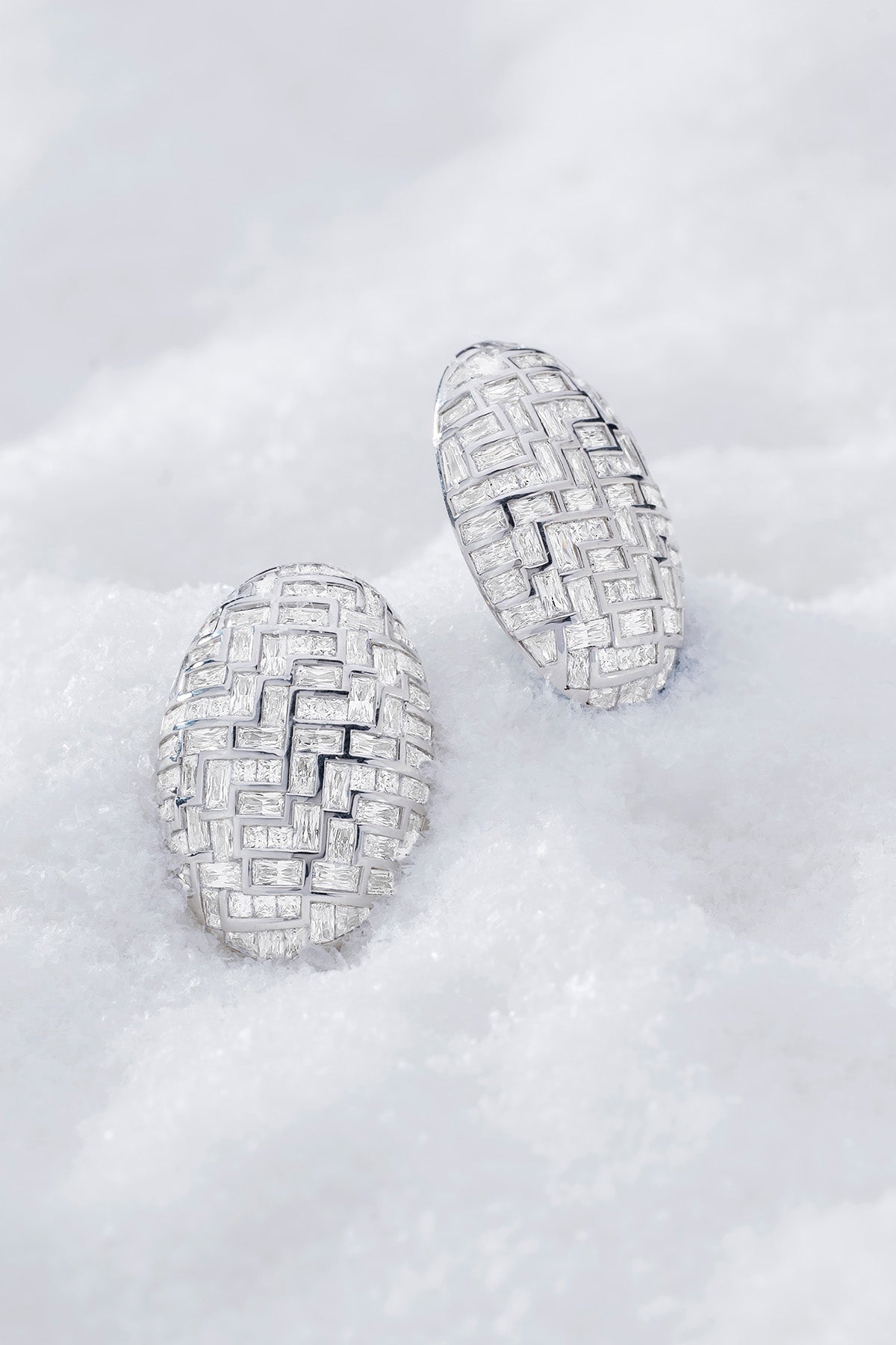 Pair of statement labyrinth earrings in silver from APM MONACO and on a soft white surface