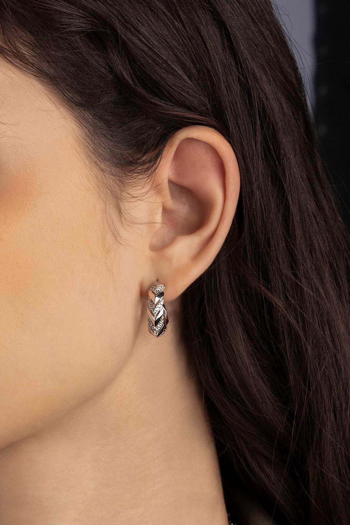 Close-up of an ear wearing a silver earring