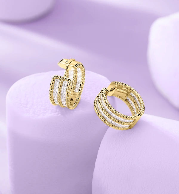 APM MONACO torsade pave earrings in yellow gold on purple background