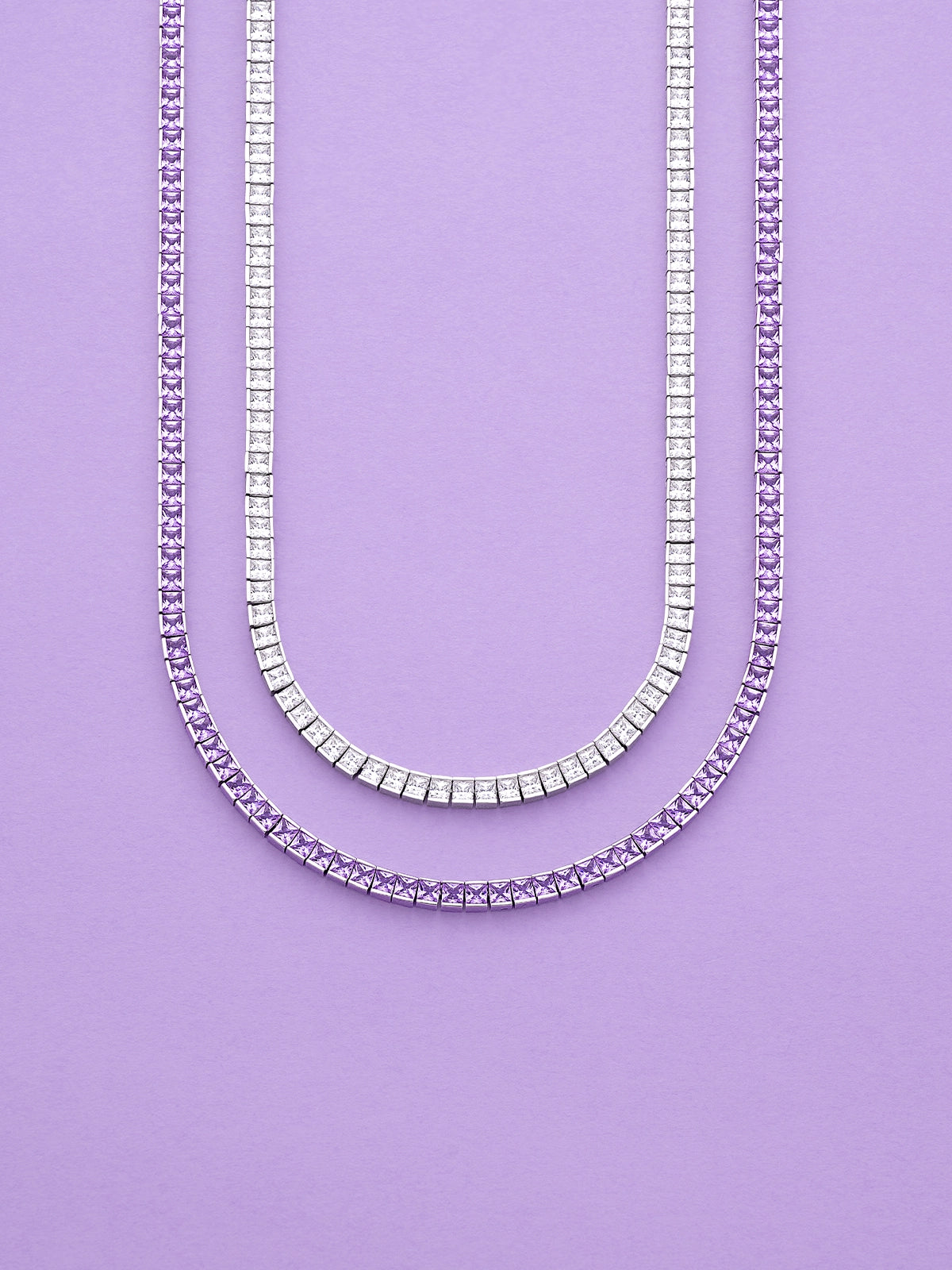 APM MONACO Printemps necklaces in silver and purple on a purple background