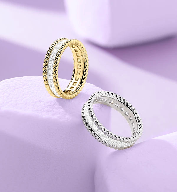 Two APM MONACO torsade pave rings on purple background