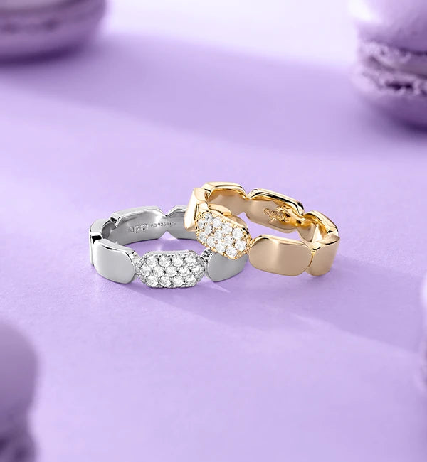Two APM MONACO rings on purple background, one is in silver one is in yellow gold