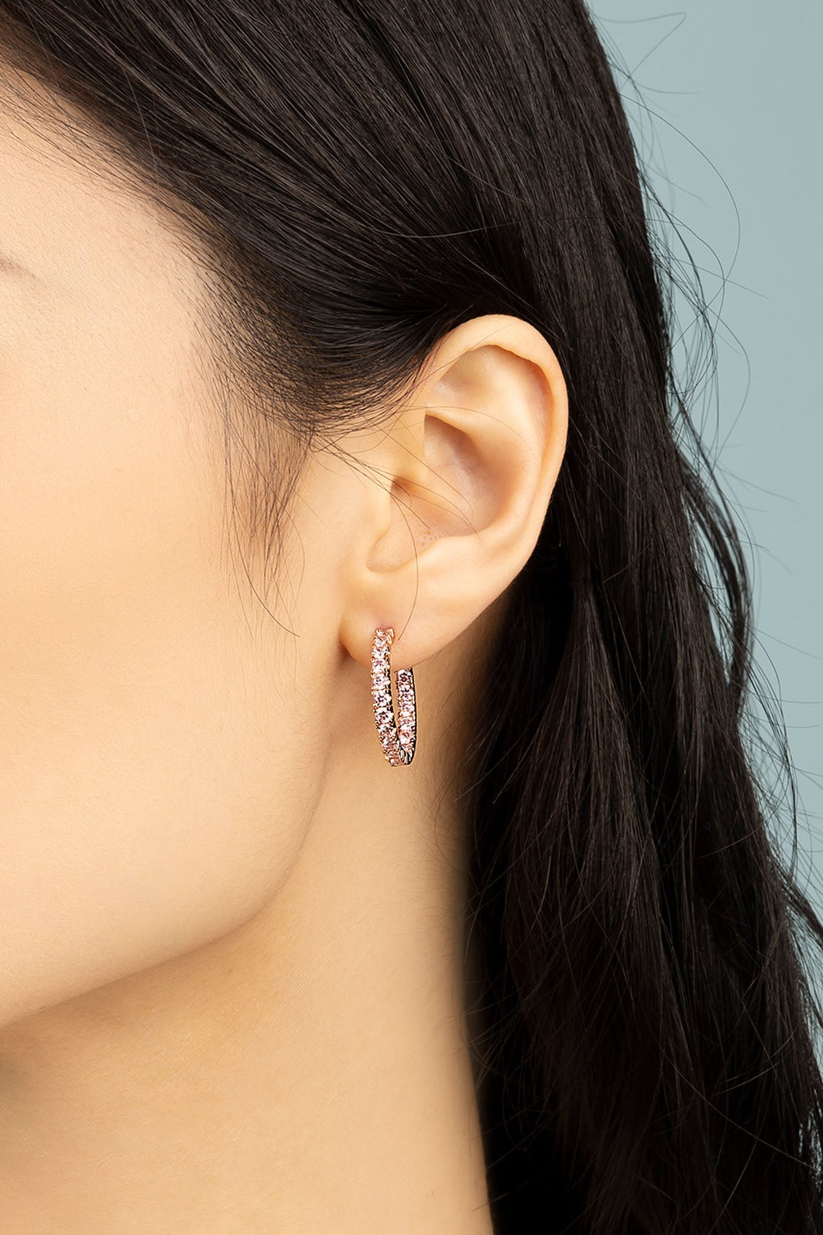 Earrings APM Monaco rose gold pavé hoop earrings with pink stones.