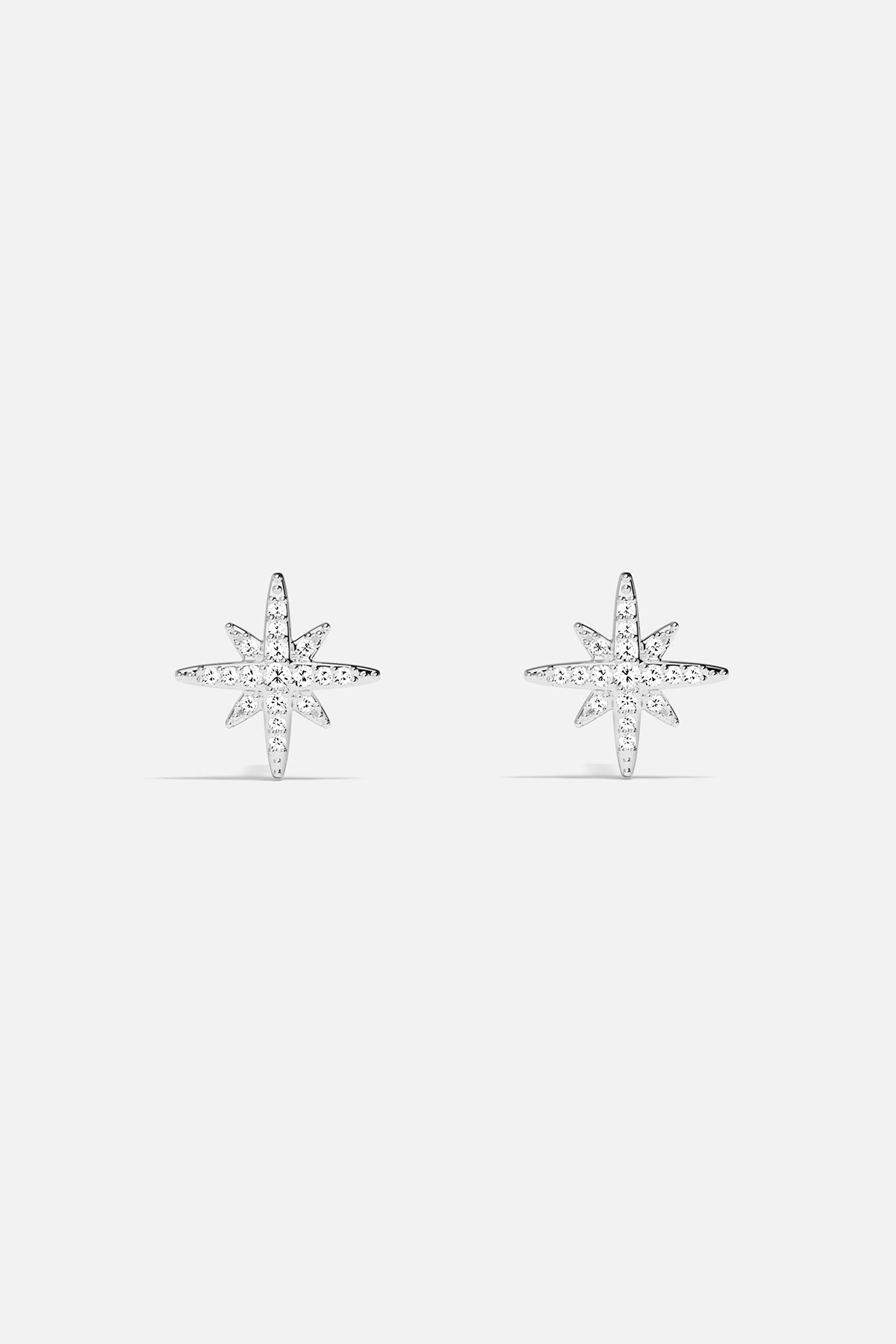 Earrings APM Monaco: Silver-tone starburst stud earrings with white stones.