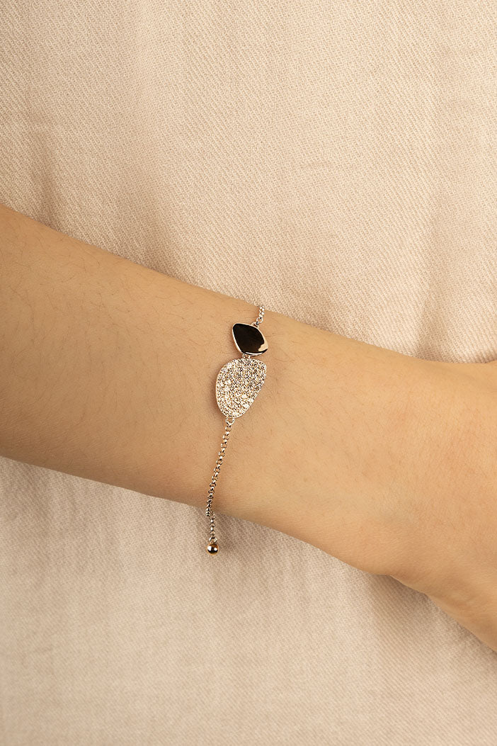 Bracelets APM Monaco Galet Adjustable Bracelet on a fair-skinned wrist; slender metal band with pavé, light-colored stones.