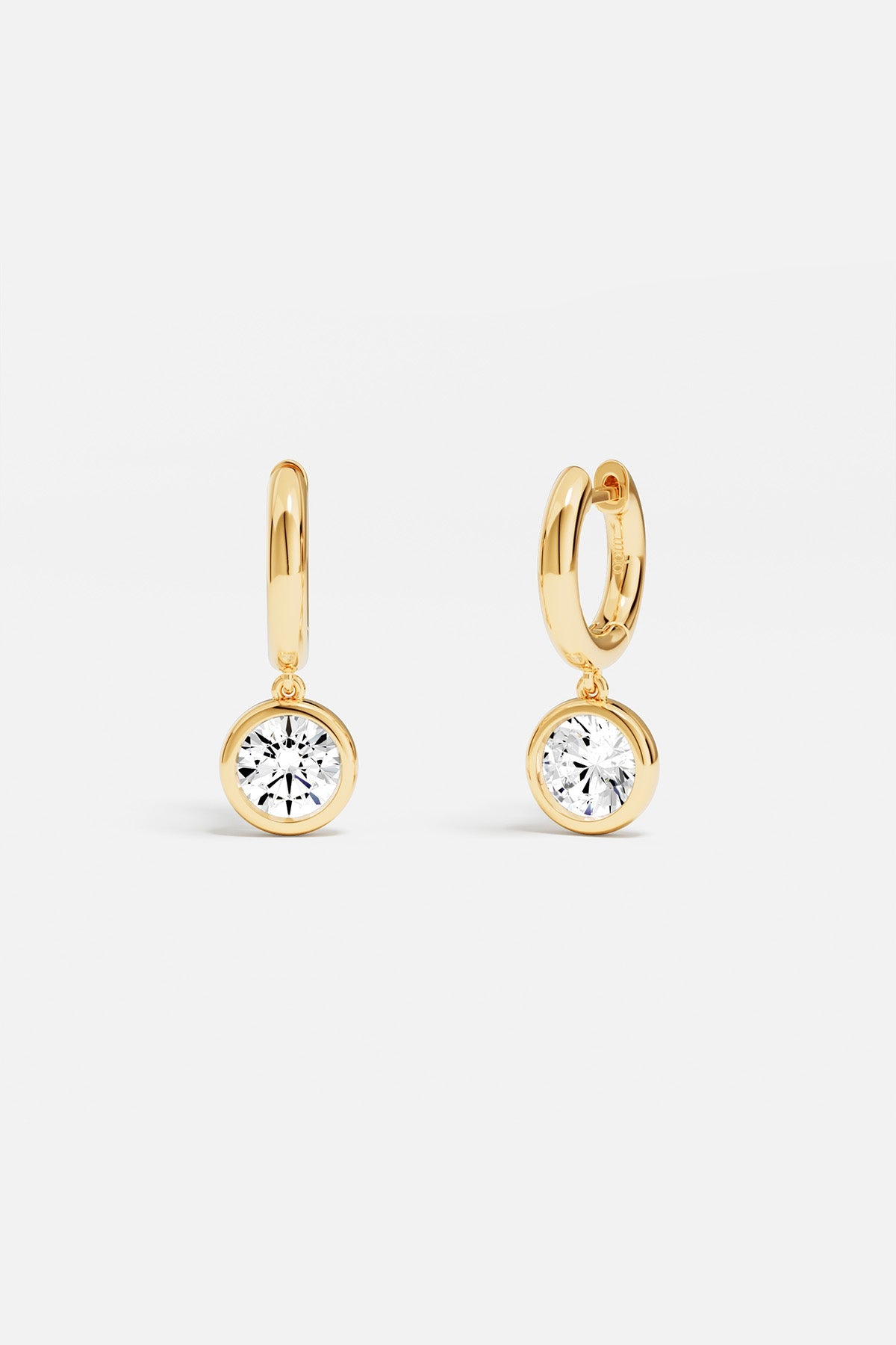 Earrings APM Monaco, gold hoop earrings with white gemstone dangles.