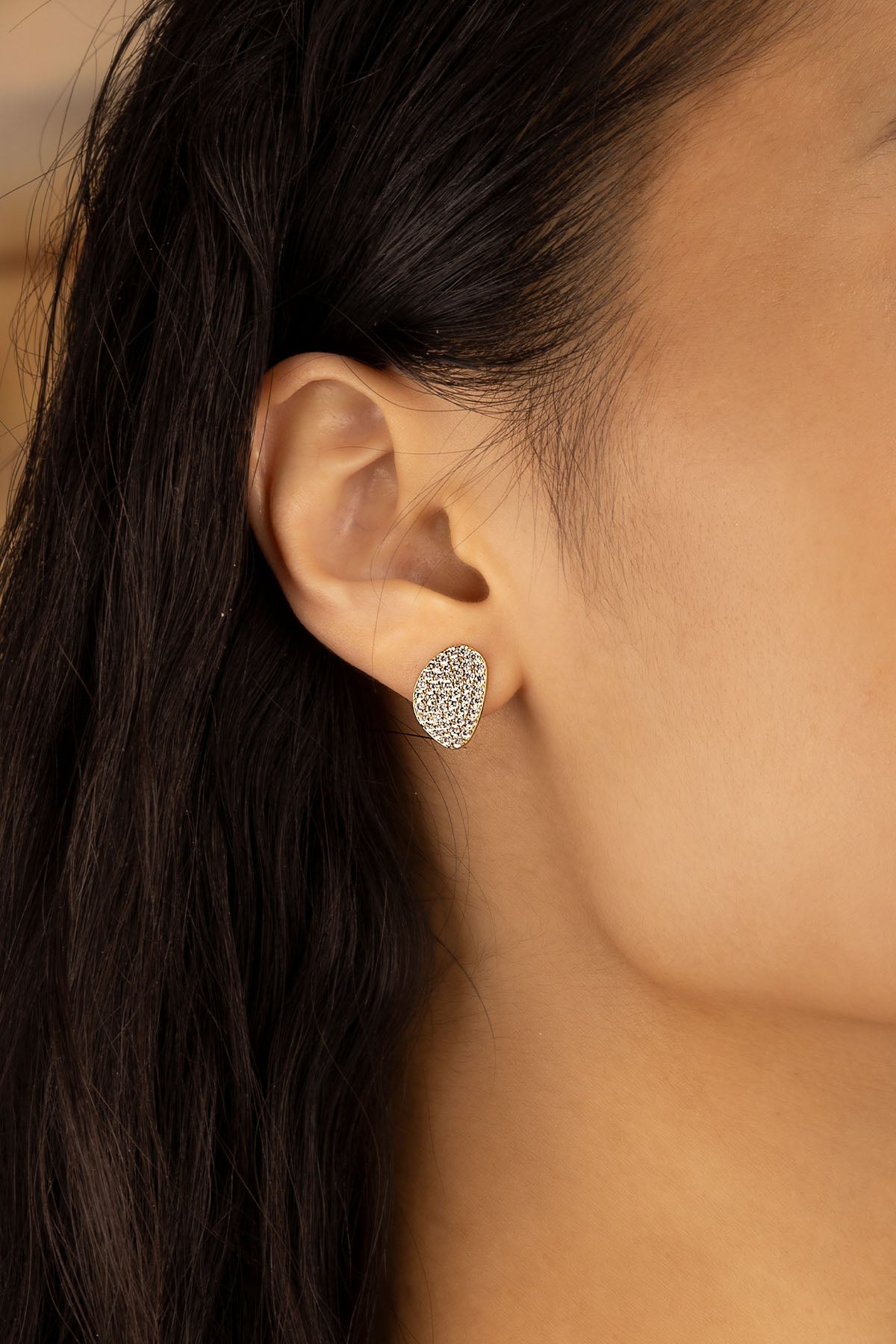 Earrings APM Monaco yellow gold pavé oval stud with white rhinestones.