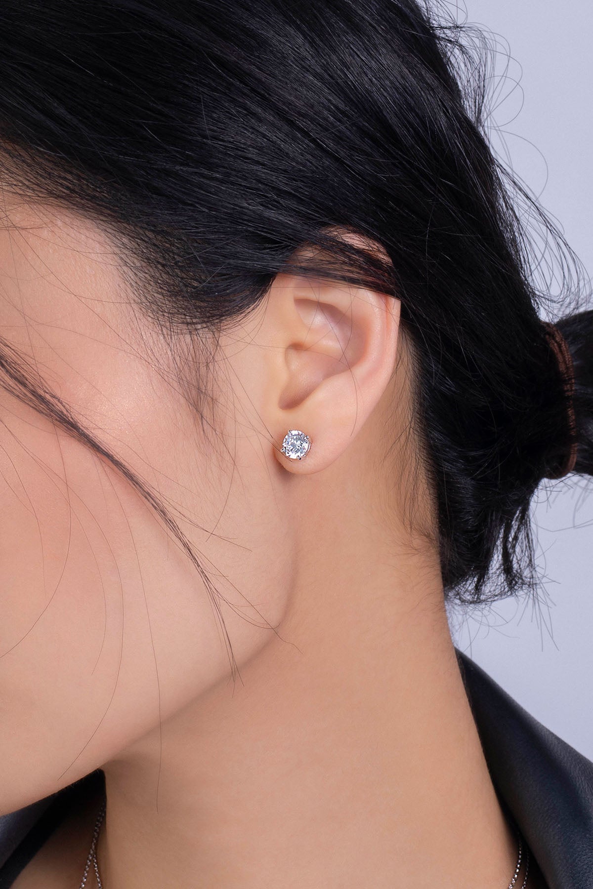 Earrings APM Monaco round stud with white crystal in a silver-tone setting.